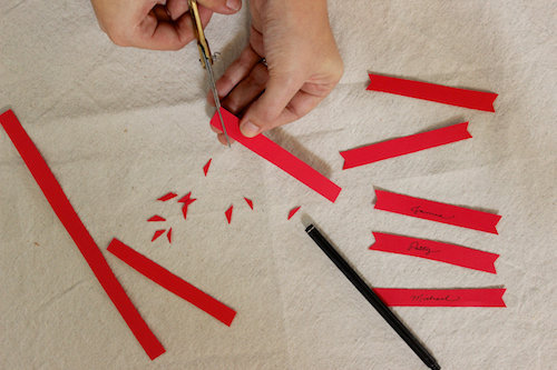 Découpez les bannières en V avec les ciseaux, puis écrivez les noms.