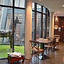 Un jardin intérieur apporte une douce lumière à la salle à manger éclairée par de larges baies d'atelier.