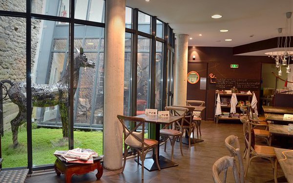 Un jardin intérieur apporte une douce lumière à la salle à manger éclairée par de larges baies d'atelier.