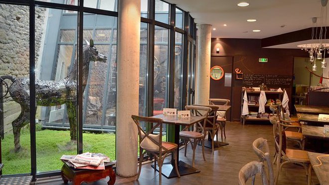 Un jardin intérieur apporte une douce lumière à la salle à manger éclairée par de larges baies d'atelier.