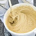 Etape 2 : La préparation du mélange de sous-enduit à la chaux aérienne sert également pour les plots de calage.