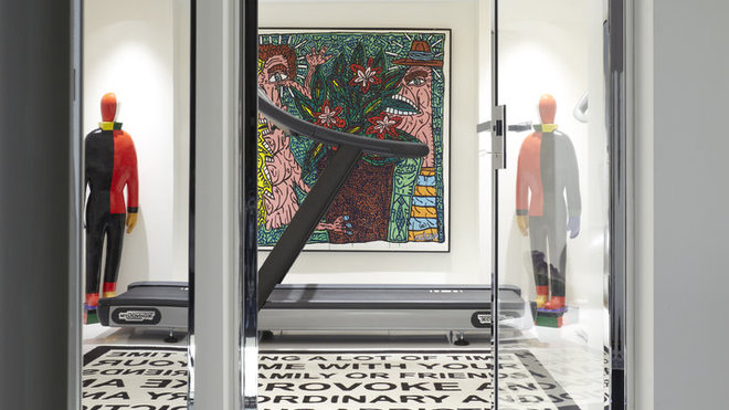 Dans la salle de sport, l'appareil de musculation fait face à une splendide toile de Combas. Tapis, Jean-Charles de Castelbajac.