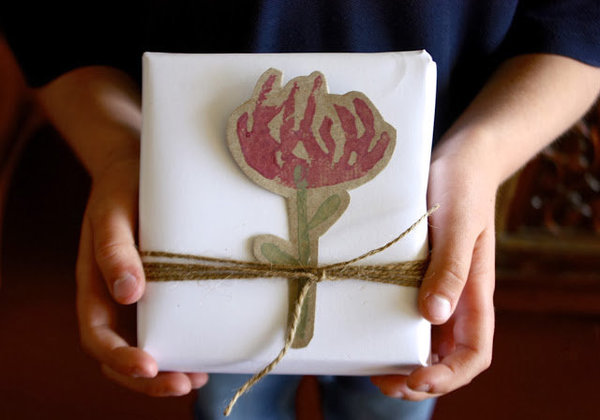 Une étiquette, un lien de raphia qui donnent un cadeau bien empaqueté.