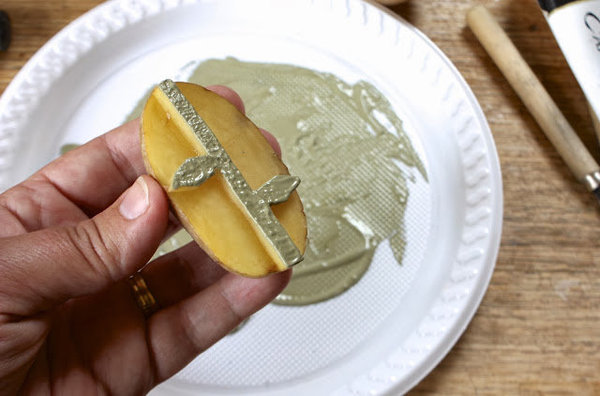 Imprégnez le motif tige et feuilles de peinture déposée dans l'assiette.