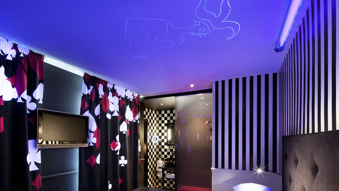 La chambre « Joker » avec des rideaux aux couleurs des cartes à jouer et une silhouette qui apparaît au plafond, lorsqu’on allume la lumière.