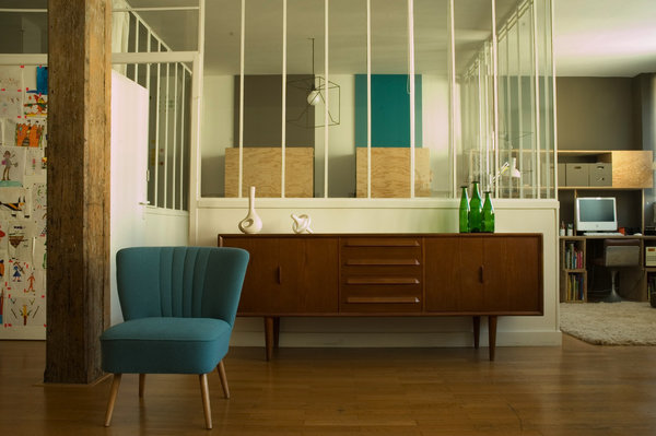Du salon, la chambre se fait discrète malgré les baies vitrées. Les armoires dessinent des aplats de couleurs et matières. Bouteilles en verre coloré, création Jasper Morrison.