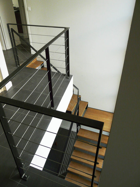 La structure en acier de l’escalier intérieur dessine des lignes aériennes, qui mettent en valeur les marches en chêne.