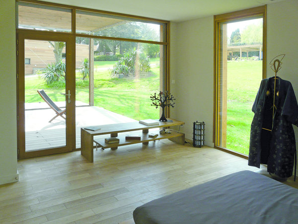 Une alternance de châssis fixes et de portes battantes rythme la façade sud. Chaque pièce offre un accès individuel à la terrasse.