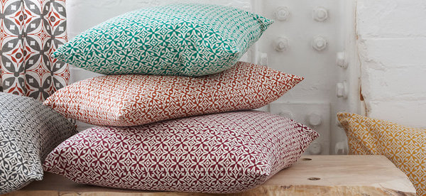 Coussins et rideaux dans les tissus d'Akin & Suri.