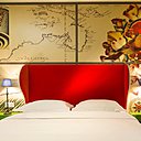 Le fauteuil richement décoré de cette chambre colorée à l’image de l’Océanie invite à la détente sous l’œil attentif de l’oiseau tropical du papier-peint.