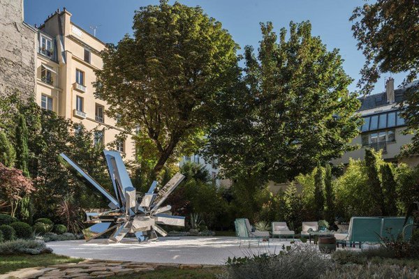 Tel un Vishnou du futur, sculptural et monumental,le RockGrowth  d'Arik Levy s'élance versle ciel. Les 21 bras en inox poli miroir s'installent dans les jardins de l'Enclos des Bernardins, aménagés par l'architecte d'intérieur Chahan Minassian.