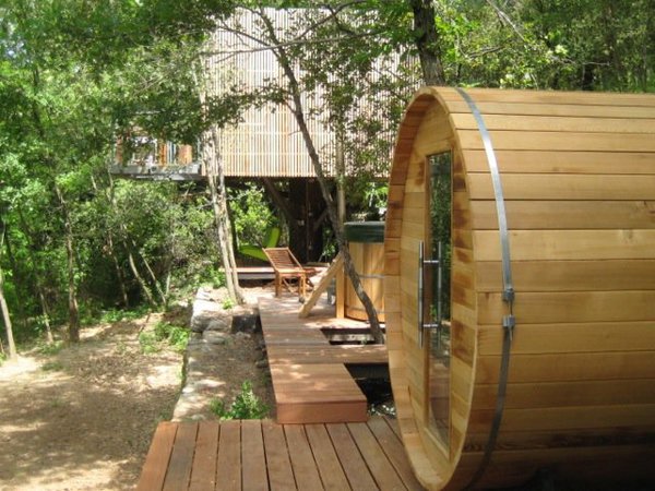 Le hot tub et le sauna sont tous deux situés au pied de la cabane et font face à la forêt.