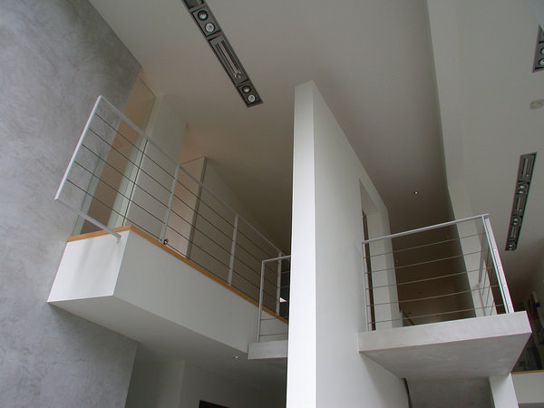 A l’étage, des espaces plus intimes se cachent. Béton et peinture blanche  dessinent les volumes.