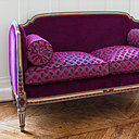 Ce canapé de style Louis XVI est revisité avec un tissu en velours uni et à motif. Les boiseries sont patinées subtilement en rappel des coloris du tissu.