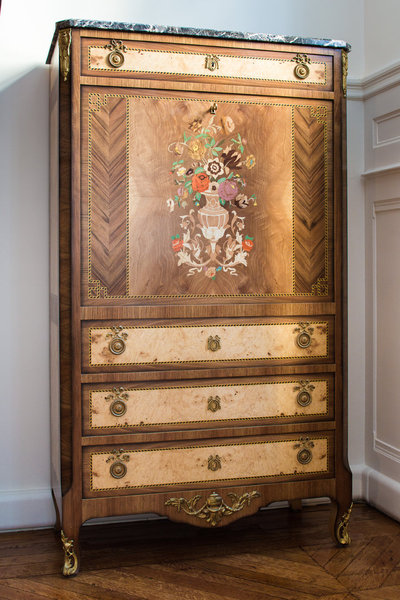 Ce secrétaire à abattant transition (période entre la fantaisie Louis XV et le classicisme Louis XVI) mélange essences de bois exotique et marqueterie.