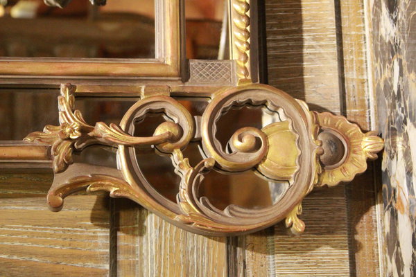 Le détail d’un miroir, que les ateliers fabriquent sur commande, met l’accent sur le travail raffiné des moulures et des ornements aux patines subtiles.