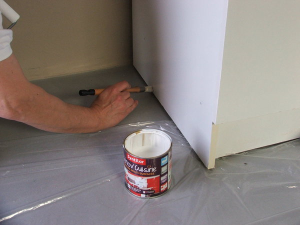 Etape 11 : Une bâche plastique protège le sol et facilite la peinture des bases des meubles.