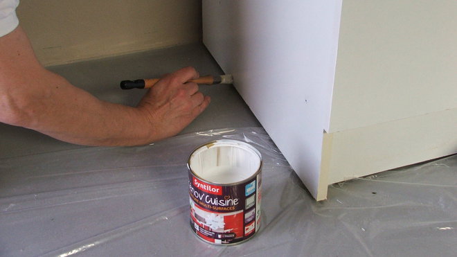 Etape 11 : Une bâche plastique protège le sol et facilite la peinture des bases des meubles.