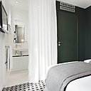 Les murs de cette chambre immaculée sont ponctués par un pan peint vert sapin, qui met en valeur le côté élégant de l’espace et la décoration très pure.