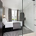 La salle de bains est séparée du lit par une cloison en verre qui ne brise pas le volume de la chambre, agrandit l’espace et offre de la lumière à l’espace bain.