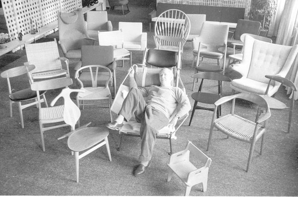 Le designer au centre de ses créations. Au cours de sa longue carrière, il créera plus de 500 modèles de chaises et de fauteuils.