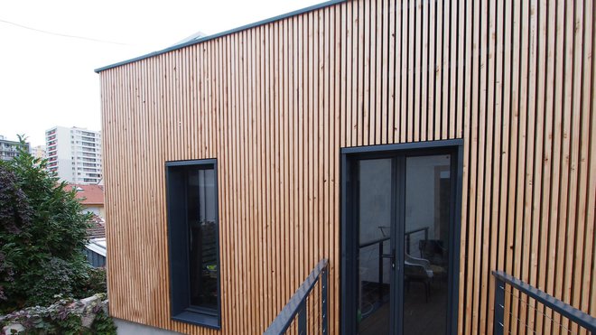 L’accès à l’atelier se fait depuis l’étage du bâtiment principal par une passerelle en aluminium thermolaqué, comme les menuiseries.