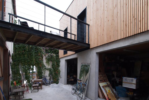 La surélévation, connectée à la construction d’origine, est réservée aux activités professionnelles et artistiques du propriétaire, tandis que la première maison est dédiée à la vie privée.