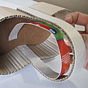 Etape 7 : Renforcez l'anse en collant, à la colle chaude, la bande de carton gris de 32 cm x 2 cm sur le côté extérieur de l'anse. De même, collez la bande de 29,5 cm x 2 cm sur le côté intérieur de l'anse.