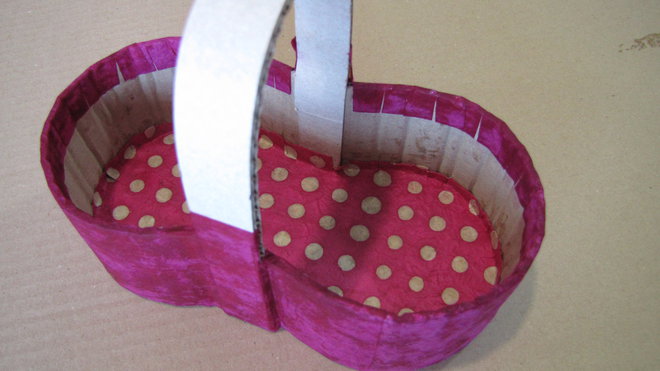 Etape 9 : Pour le fond intérieur, déposez le panier sur la feuille de papier décoratif, tracez le contour extérieur du panier. Découpez la forme en laissant une marge de 1 cm tout autour. Crantez la marge tous les 1 cm environ. Appliquez la colle à papier peint sur l'envers du papier. Glissez le papier à l'intérieur du panier. Lissez bien, en faisant remonter les crans le long des parois.