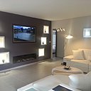 Le salon lumineux intègre une cloison pour insérer une cheminée et l’écran TV.