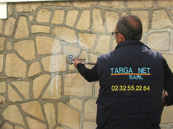 Etape 6 : Commencer la pulvérisation du produit en le passant du haut vers le bas du mur de pierre ; ne pas hésiter à charger en produit afin de bien imprégner la pierre.