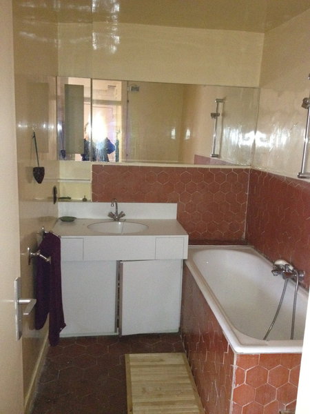 Avant : la salle de bains d’origine avec son carrelage et ses équipements rétro.