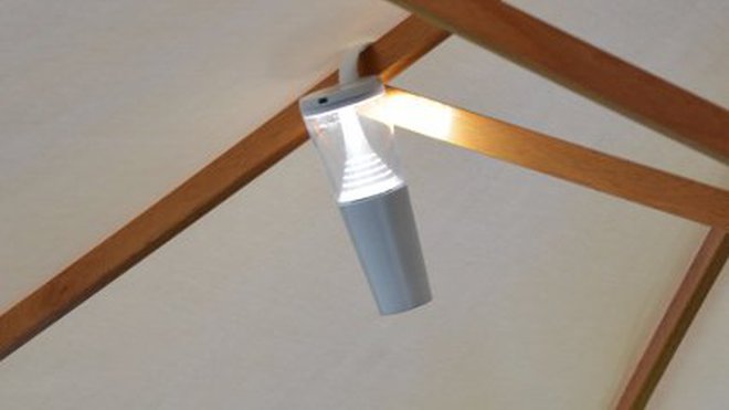 Accrochée aux baleines d’un parasol, la lampe solaire Butterfly éclaire discrètement votre table de jardin.
