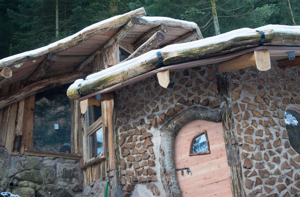 Semi-enterrée, la Maison du Hobbit est creusée dans la roche pour se fondre avec la montagne.