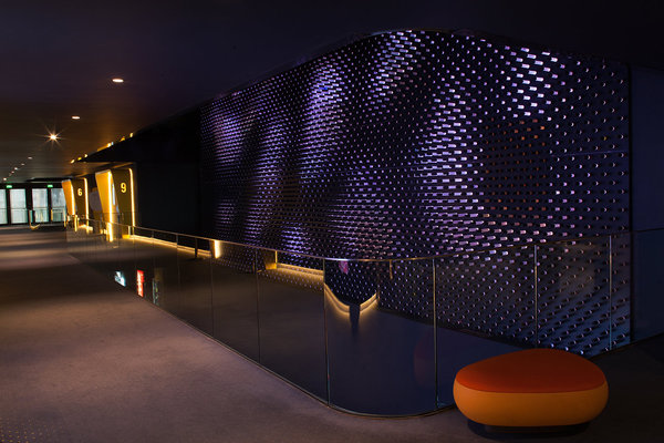 Dans les couloirs d’accès aux salles, des galets au sol et des courbes organiques accompagnées par la lumière.