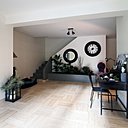 L’entrée de la maison sert de sas entre la salle à manger et le salon. Des cloisons coulissantes permettent un isolement temporaire des deux pièces. Au fond, l’escalier permet d’accéder au 1er étage, le royaume des enfants.