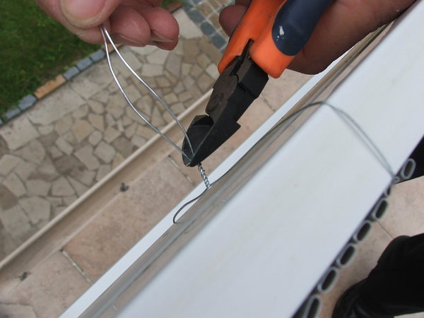 Etape 5 : A la pince coupante, couper le surplus du fil d’acier de fixation. Veiller à laisser 1 à 2 centimètres de fil d’acier enroulé.