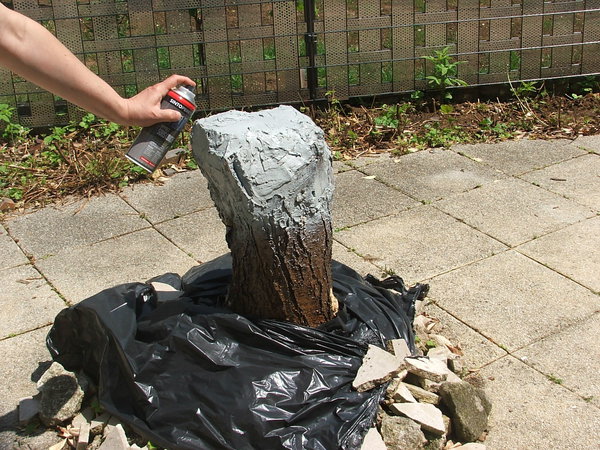 Etape 10 : Pulvériser une peinture aérosol sur le dessus de la souche du tronc d’arbre, afin de repeindre la partie enduite, et ainsi de la solidifier.