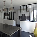 La cuisine est séparée par une baie vitrée d’atelier, créée pour donner de la lumière. Elle est ouverte en partie sur le salon.