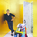 Sacha Walckhoff, directeur de la création de la Maison Christian Lacroix depuis 2010, perpétue l’esprit novateur et unique de Christian Lacroix, en présentant une collection de tissus et d’accessoires maison colorés et habillés de formes géométriques. Derrière lui, une cabine d’essayage tapissée de papier peint Christian Lacroix pour Designers Guild est dissimulée derrière une imposante porte en or.