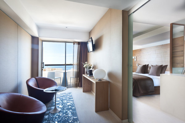 Un petit salon, attenant à la chambre est séparé par une cloison de verre coulissante avec une terrasse commune.