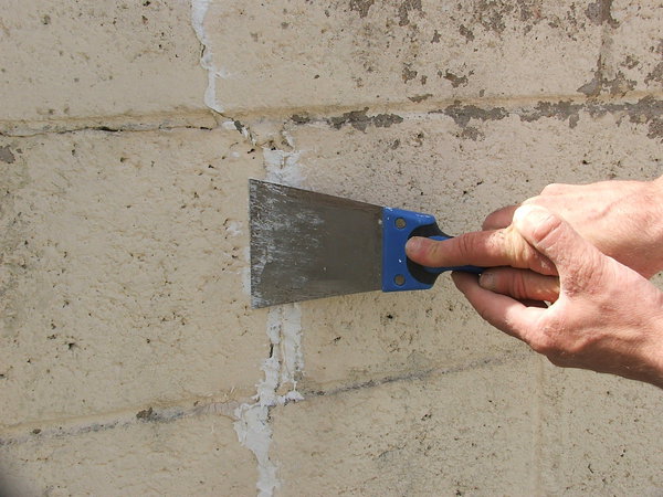 Etape 5 : Venir avec une lame à enduire rembourrer le mastic acrylique, en passant l’outil horizontalement sur le cordon.