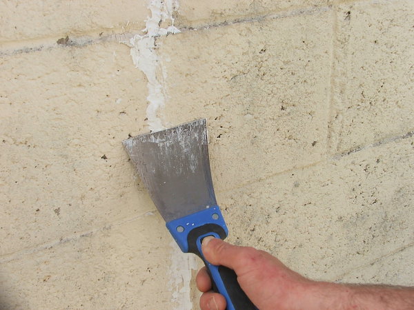 Etape 6 : Lisser le cordon de mastic acrylique en effectuant un passage de la lame à enduire dans le sens de la longueur de la fissure. Laisser sécher 2 heures le produit.