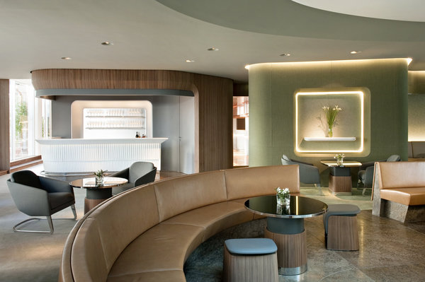 Dans le bar, les tables avec leur plateau de Stoneglass noir et leur piètement en bois et métal poli sont montées sur un piston, qui permet de les régler à différentes hauteurs, en fonction de la configuration choisie : bar ou restaurant. Les tabourets bas sont formés d’une feuille de bois cintré qui embrasse une assise en cuir grise.