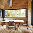 Le bardage en bois recouvre entièrement la salle des repas, attenante à la pièce commune, du sol jusqu’au plafond.