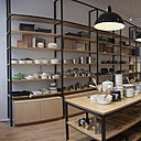 Strict et rationnel, l’aménagement réalisé avec de hautes étagères et de grandes tables rappelle les anciens bazars où l’on trouvait de tout.