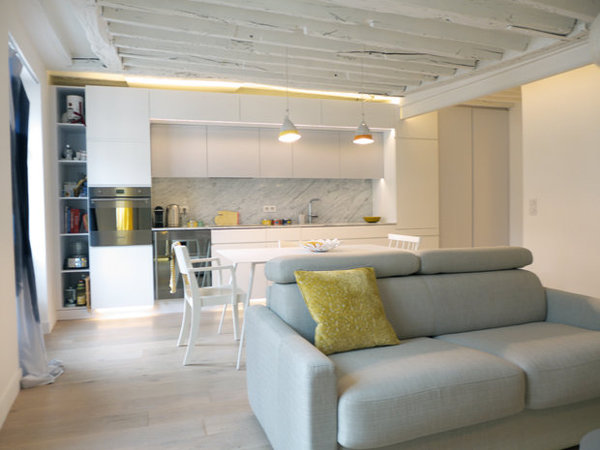 Après : Espace total tout de blanc vêtu pour la pièce à vivre où les meubles délimitent les différentes fonctions de l’espace repas et détente.