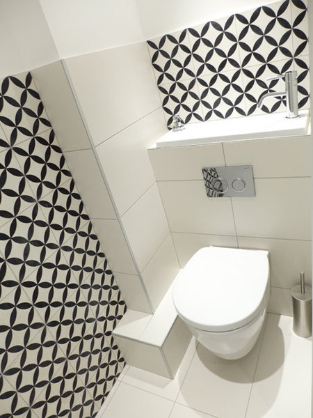 Après : Côté déco, les toilettes ont été personnalisées avec des carreaux ciment au décor graphique noir et blanc (Mosaïc Del Sur) et des dalles rectangulaires de grès cérame.