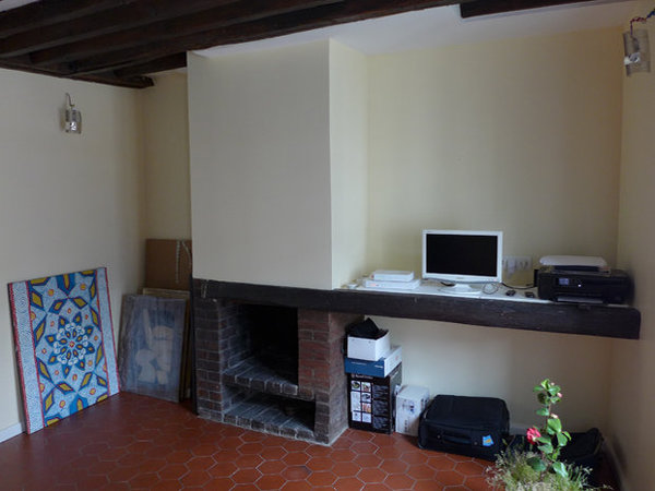 Avant : Une cheminée en brique désuète et une seule étagère en guise de rangement intégré : un aménagement démodé.