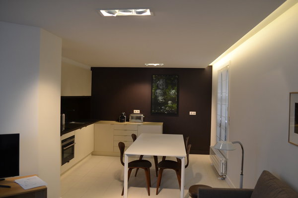 La cuisine est personnalisée par un mur de couleur marron qui a été habillé de PaperStone ®, un matériau issu du papier 100 % recyclé, aggloméré  avec des résines naturelles à base d’eau et d’huile d’anacarde (noix de cajou).